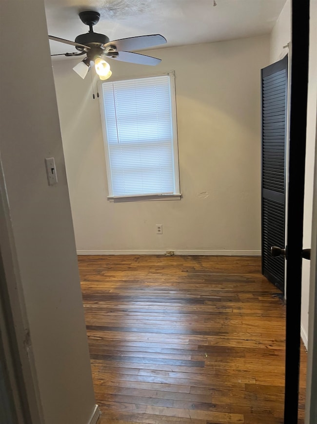 Unfurnished bedroom featuring ceiling fan and dark