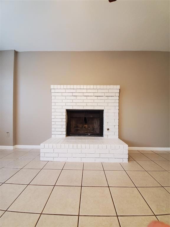 Detailed view of baseboards and a brick fireplace