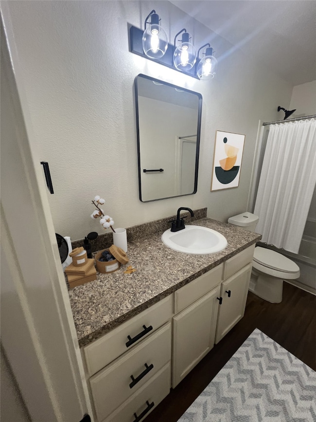 Full bath featuring vanity, wood finished floors, and shower / bath combo