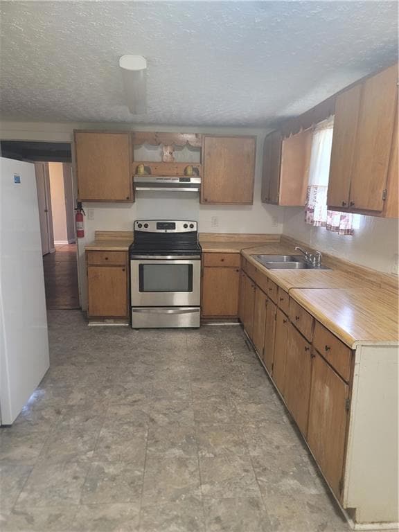 Kitchen with a textured ceiling, stainless steel electric stove, refrigerator, light countertops, and open shelves