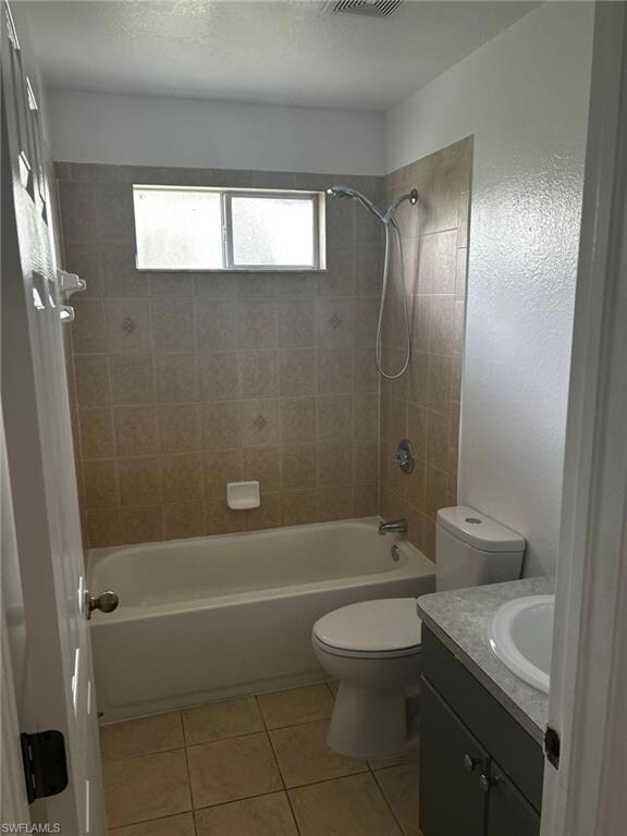 Full bath with toilet, bathtub / shower combination, tile patterned flooring, and vanity