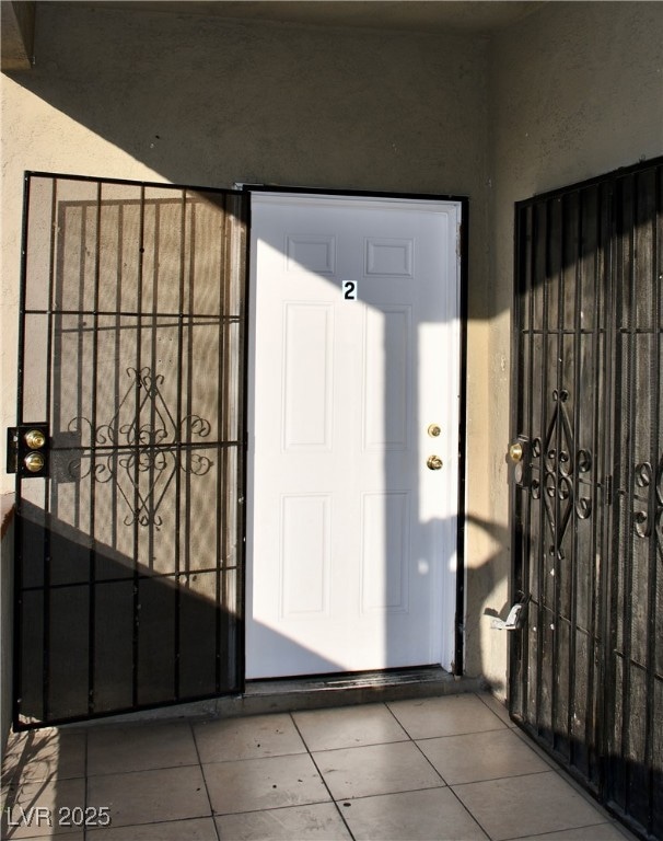 View of exterior entry with a gate and stucco sidi