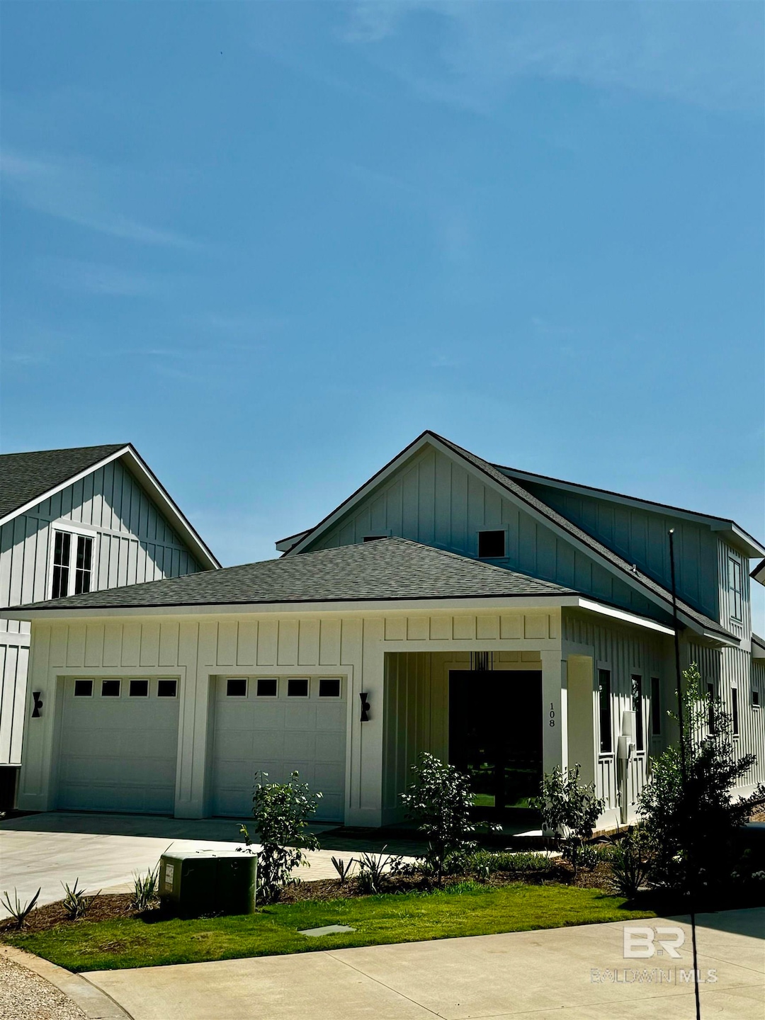 View of front of property with a garage and central AC unit