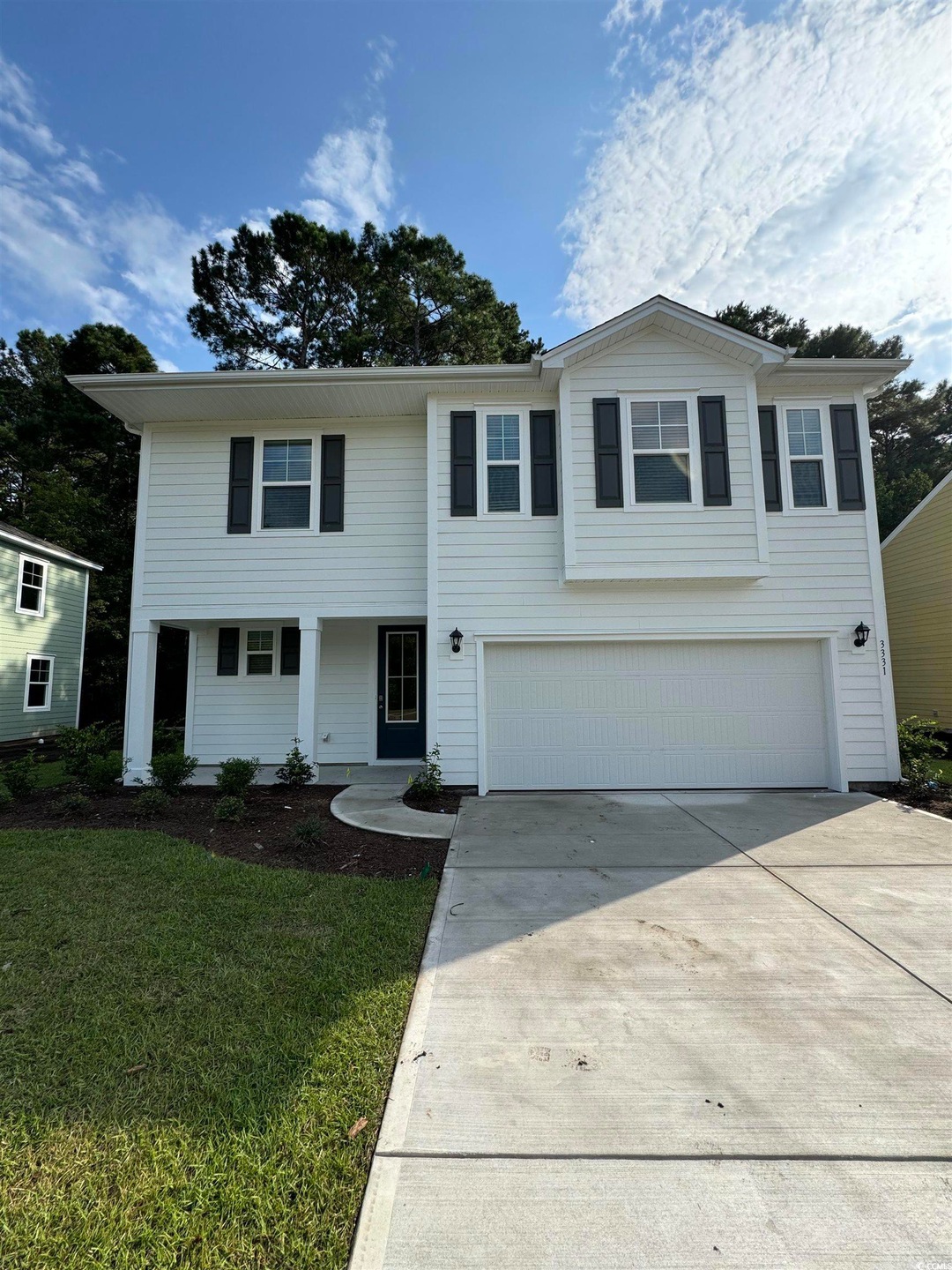 View of property featuring a garage and a front ya