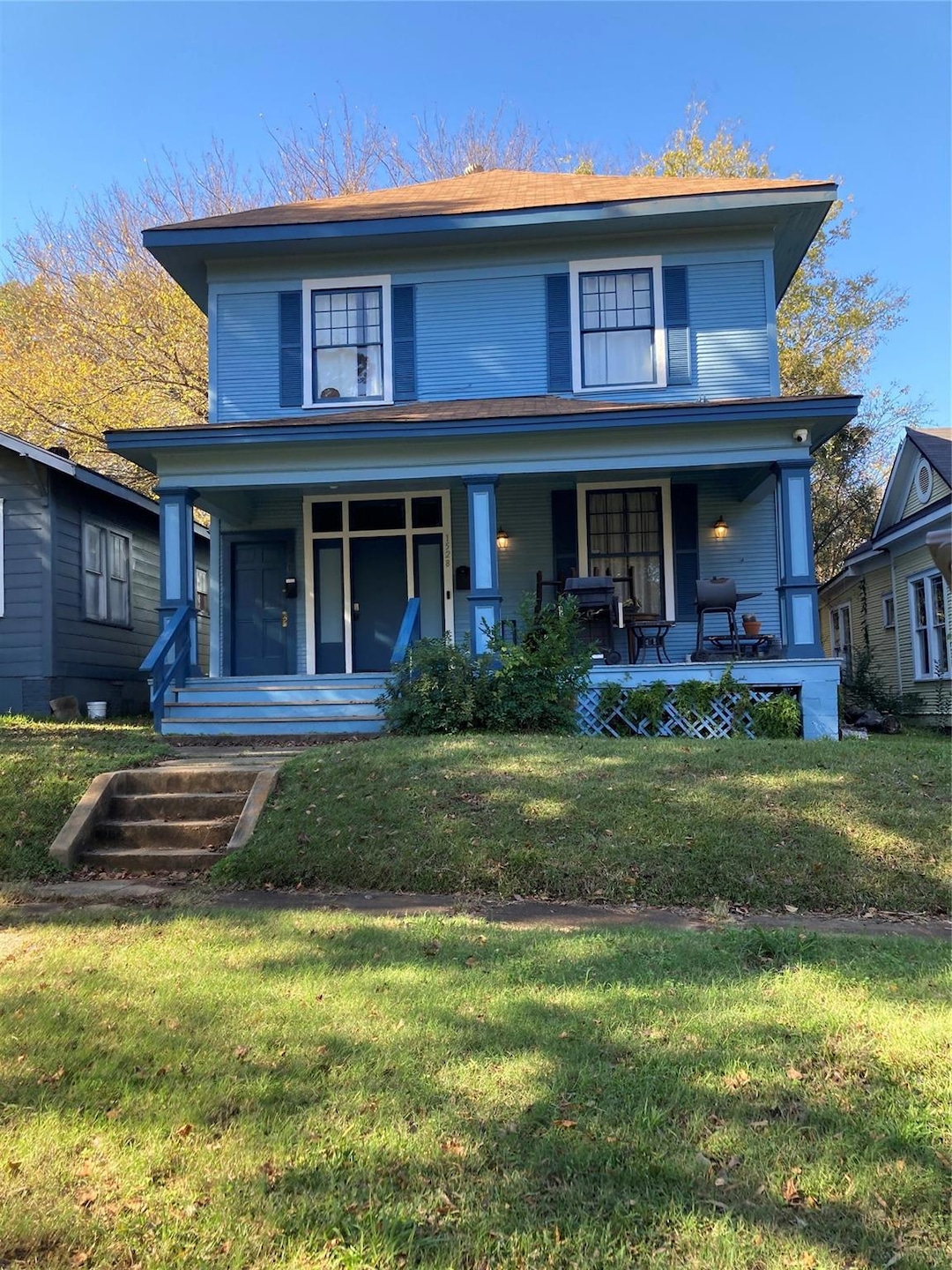 View of front property with a porch and a front ya