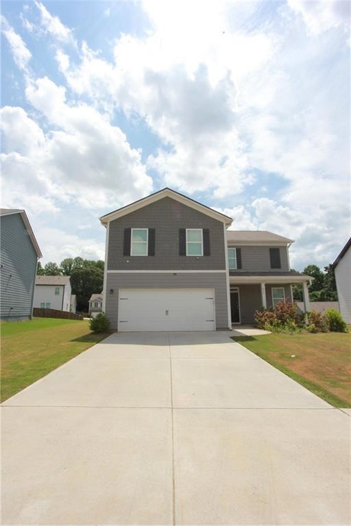 View of front of house featuring a garage and a front yard