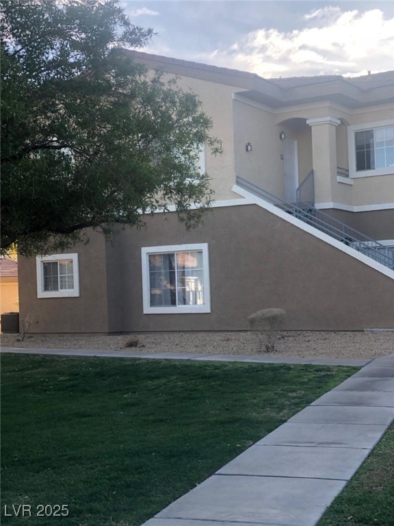 View of home's exterior with a yard and stucco sid