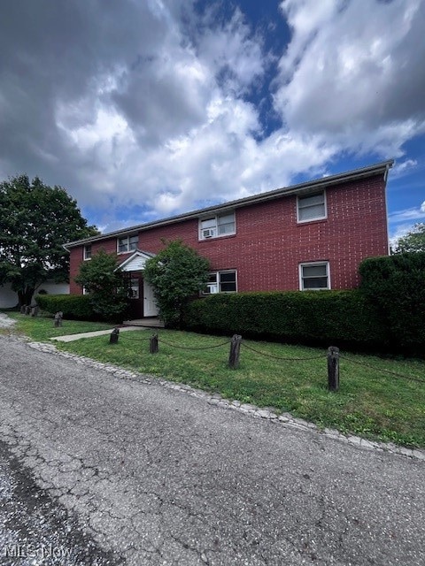 View of front of house with brick siding and a front yard