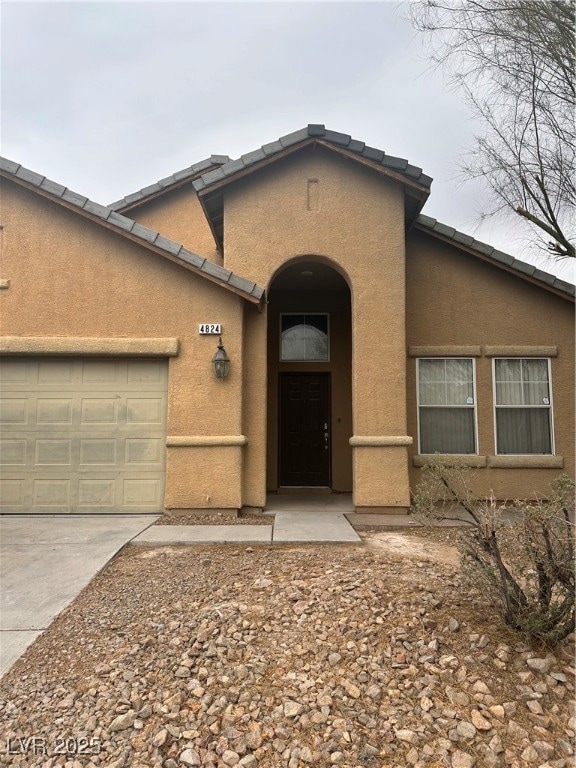 View of front of property with stucco siding, conc