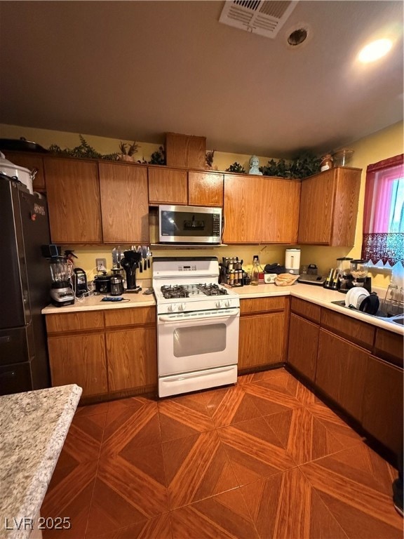 Kitchen featuring range with gas cooktop, light co