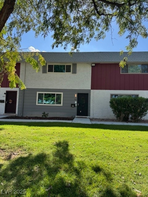View of front of house featuring a front lawn and a shingled roof