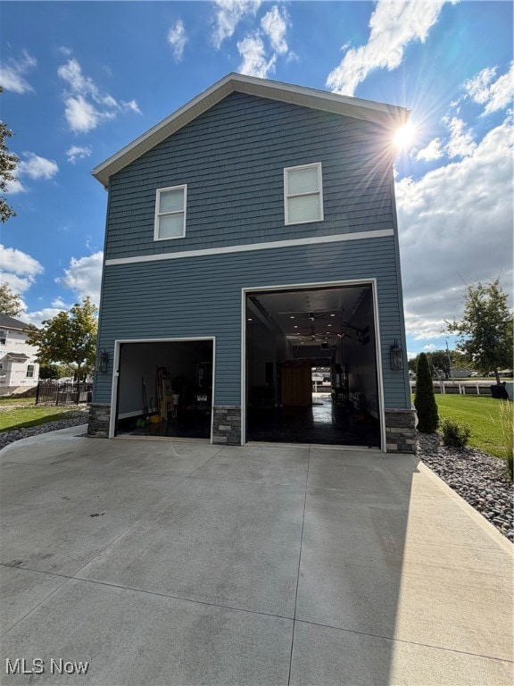 View of home's exterior featuring stone siding and driveway