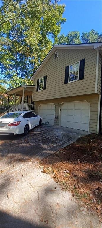 View of front of home featuring a garage and cover