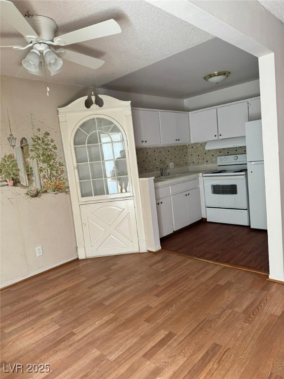 Kitchen featuring white appliances, light wood-sty