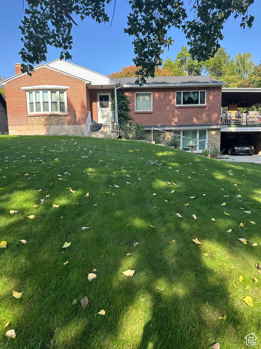 View of front of house with brick siding, a front lawn, and a chimney