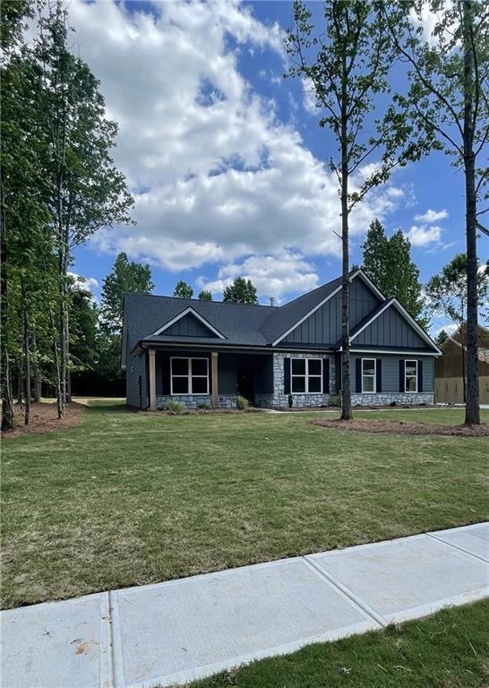 View of front of home featuring board and batten siding and a front yard