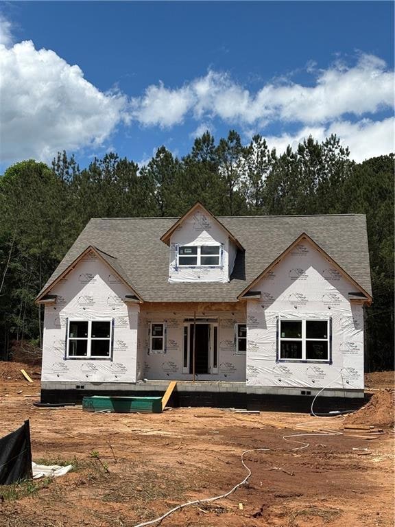 Back of property featuring a shingled roof