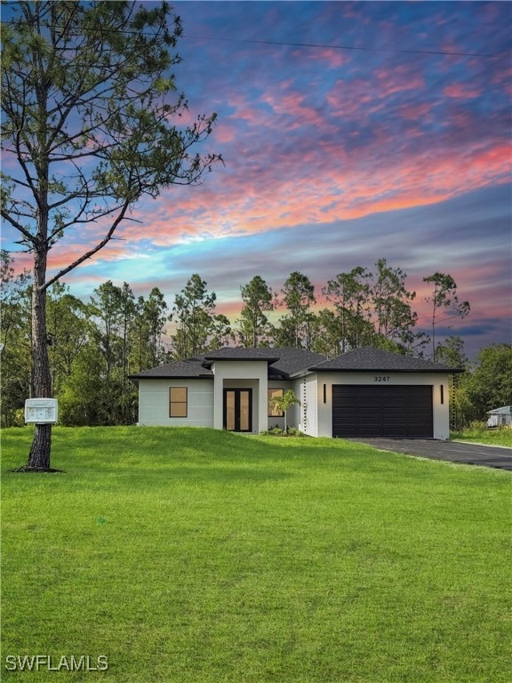 View of front of house with asphalt driveway, a ga