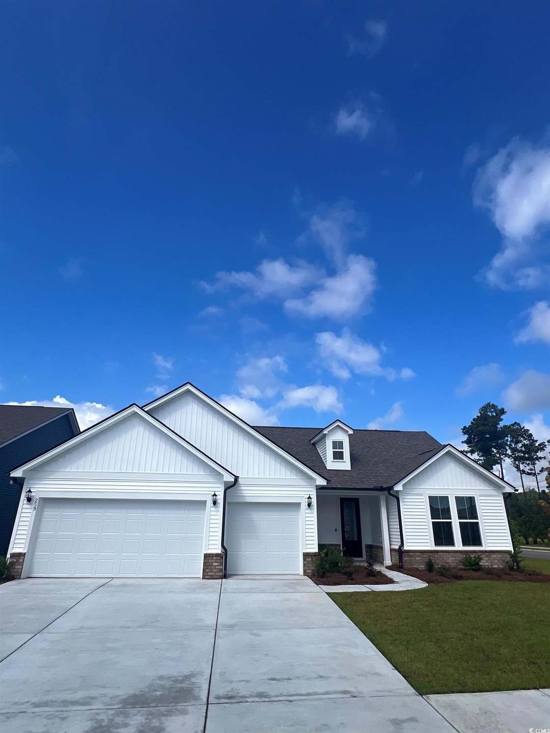 Ranch-style home with stone siding, an attached garage, concrete driveway, a front lawn, and board and batten siding