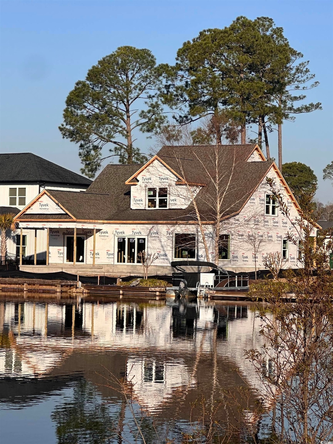 Back of house with stone siding and a water view
