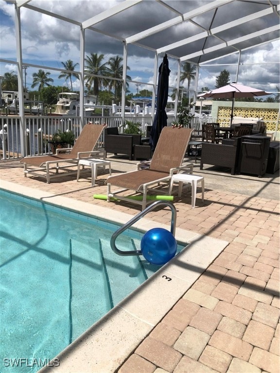 Outdoor pool featuring screened enclosure and a pa