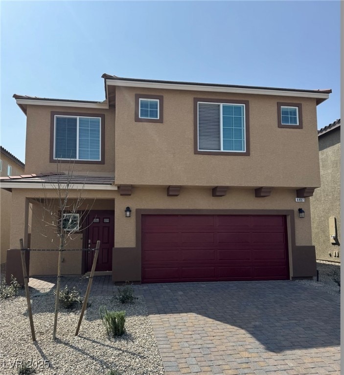 View of front of home featuring stucco siding, a g