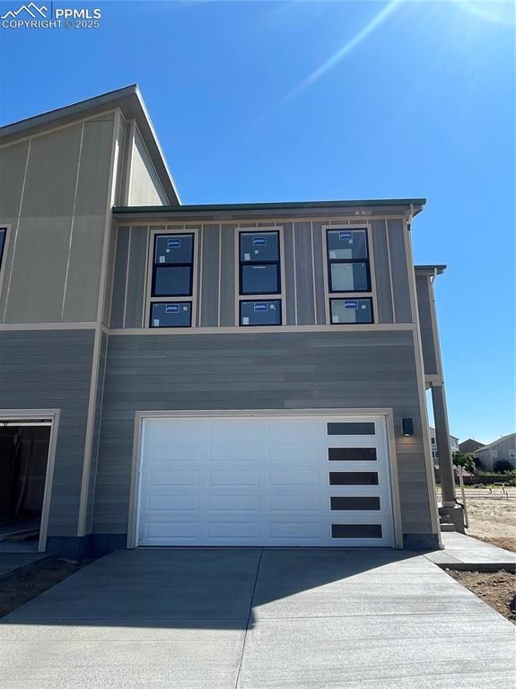 View of side of property featuring an attached garage and driveway