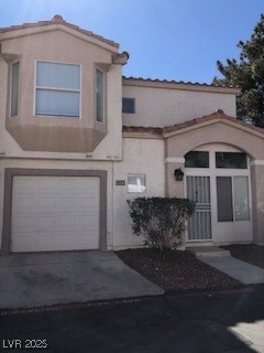 View of front of property featuring driveway, a ti