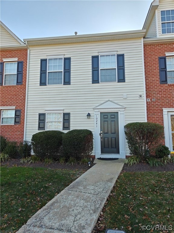 Townhome / multi-family property with a front lawn