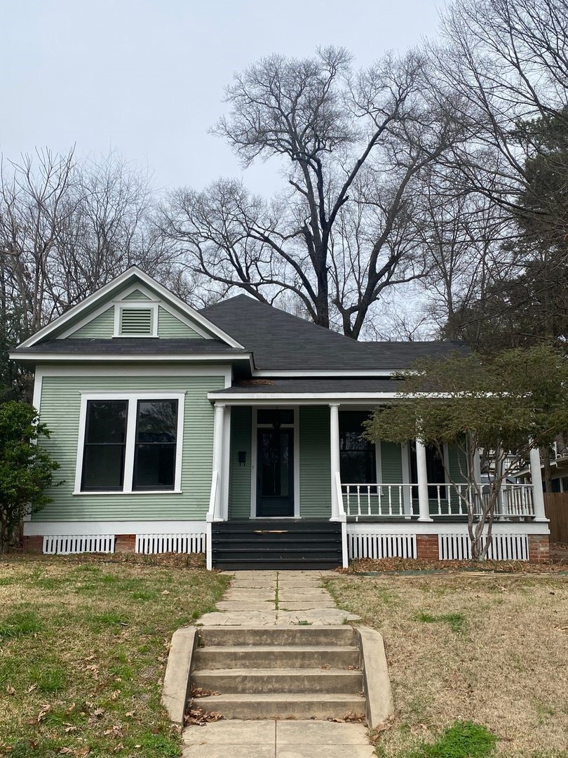 View of front of home with a porch and a front lawn