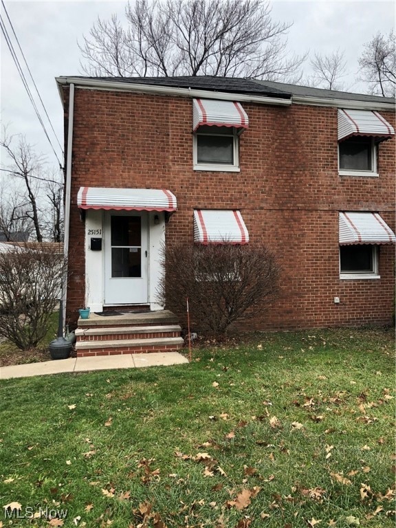 View of front of home featuring brick siding and a front lawn