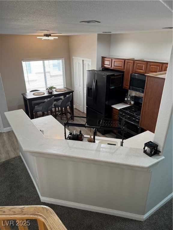 Kitchen with fridge, brown cabinetry, stove, a tex