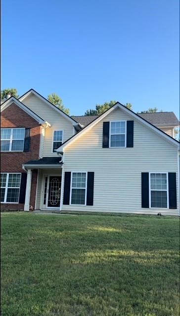Rear view of property featuring a yard