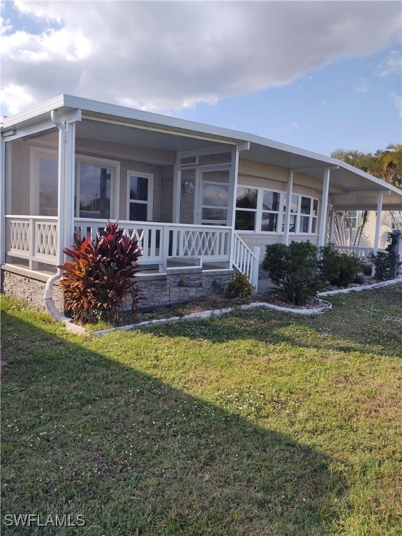 View of front of home with a sunroom and a front y