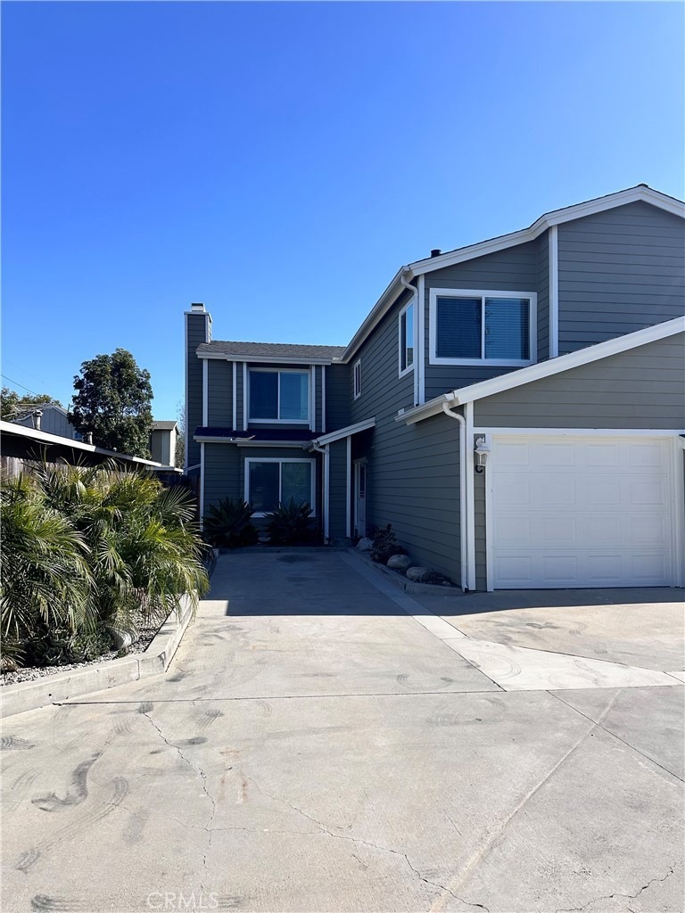 Front of unit, 1 car garage and 1 uncovered parking space