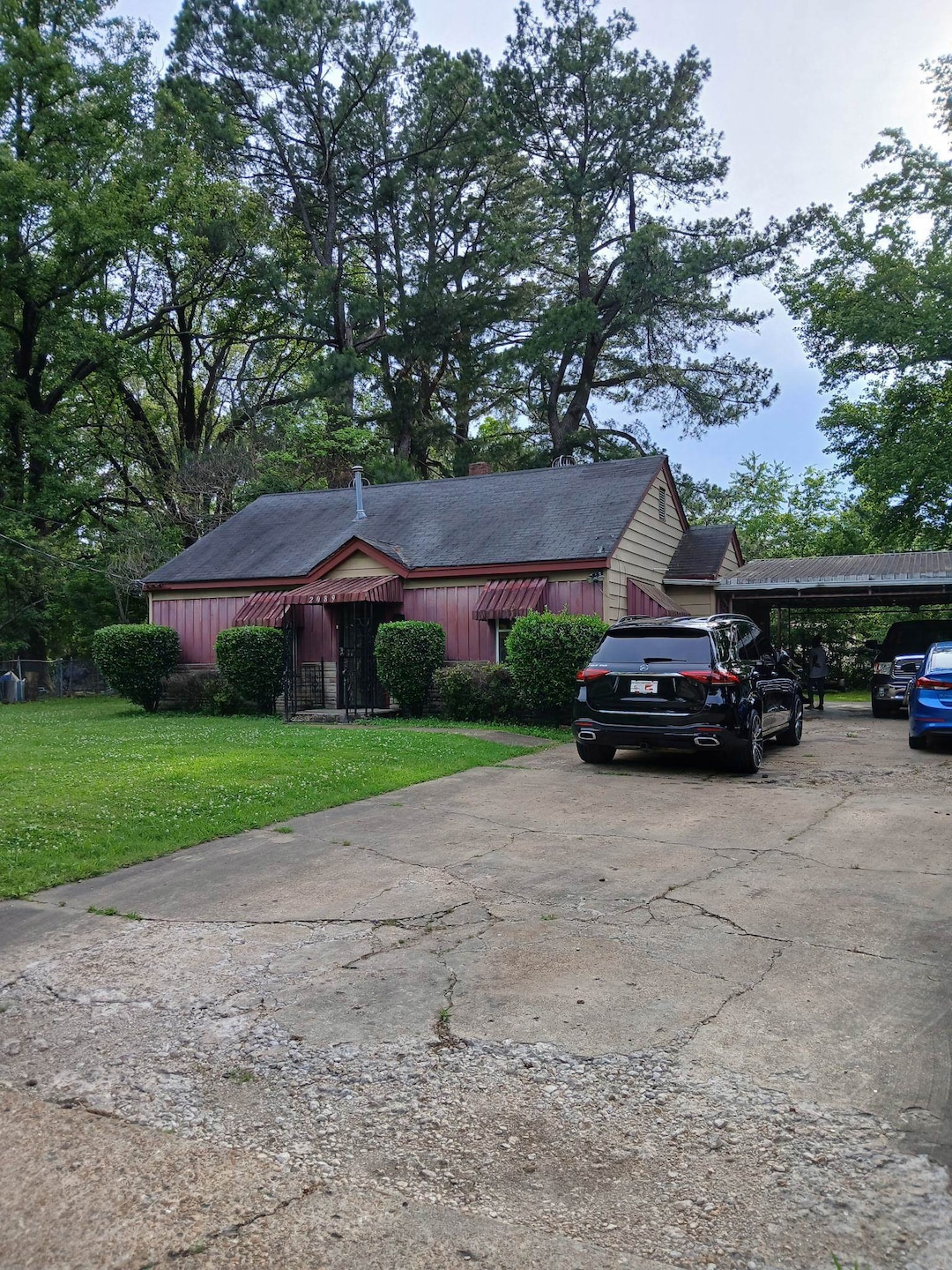 Ranch-style home featuring a front lawn, driveway, and a carport