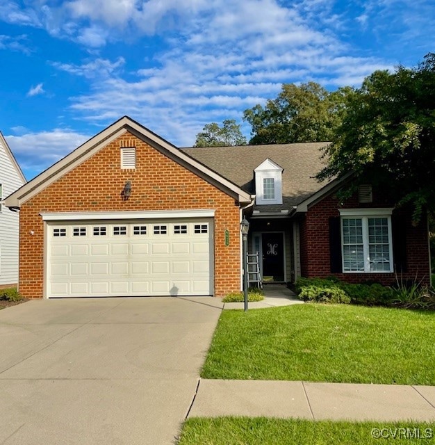 View of front facade with a garage and a front law