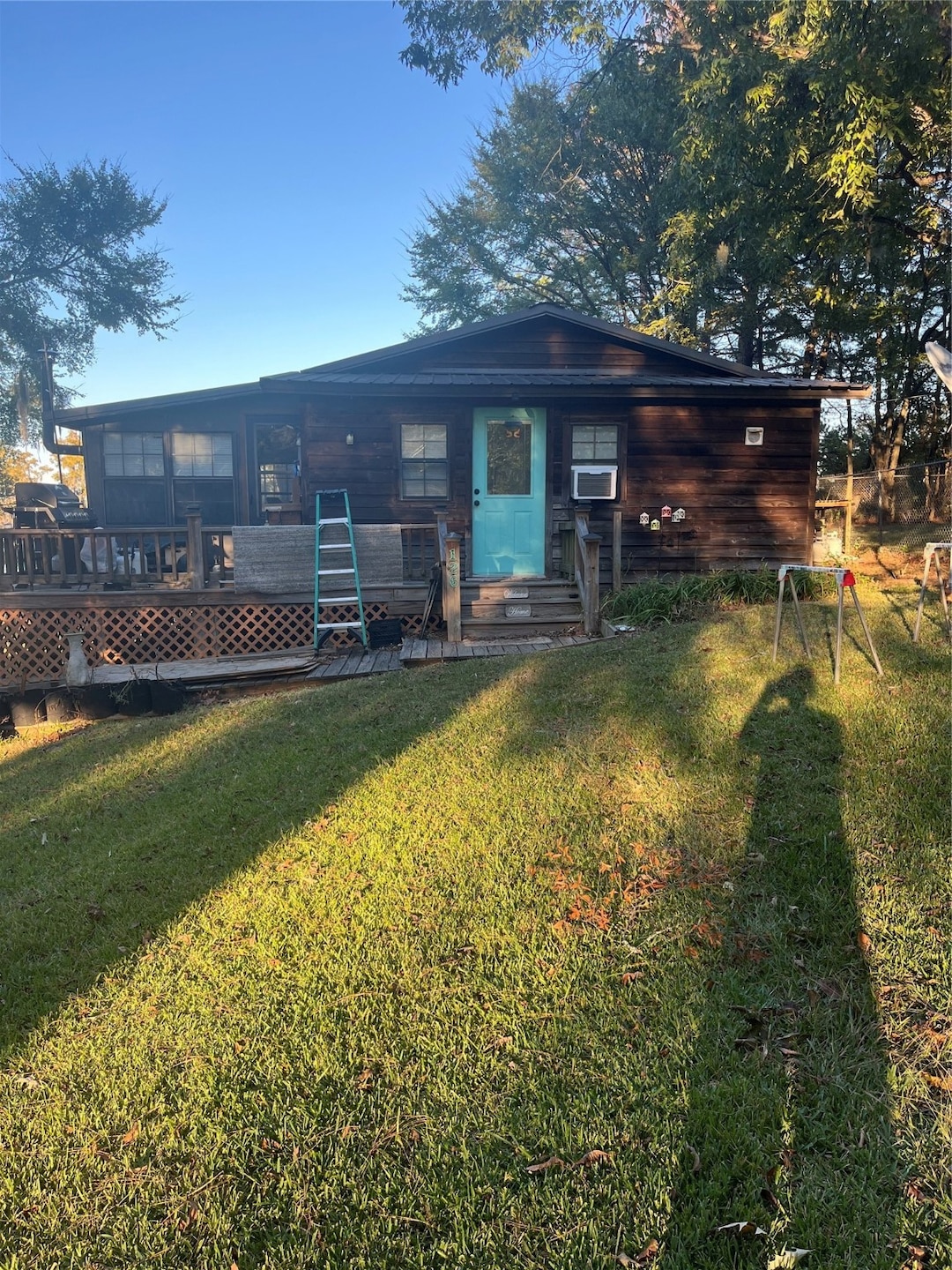 Rear view of house with a yard and a wooden deck