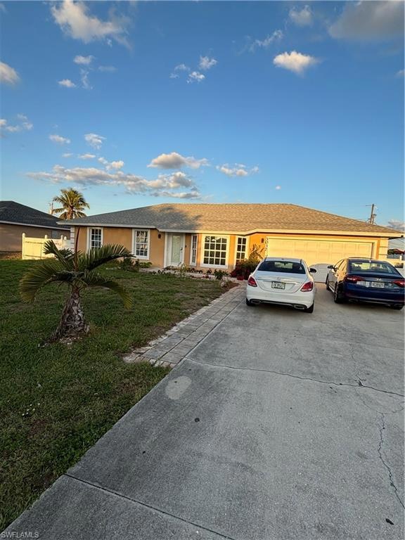 Single story home with a garage, driveway, a front