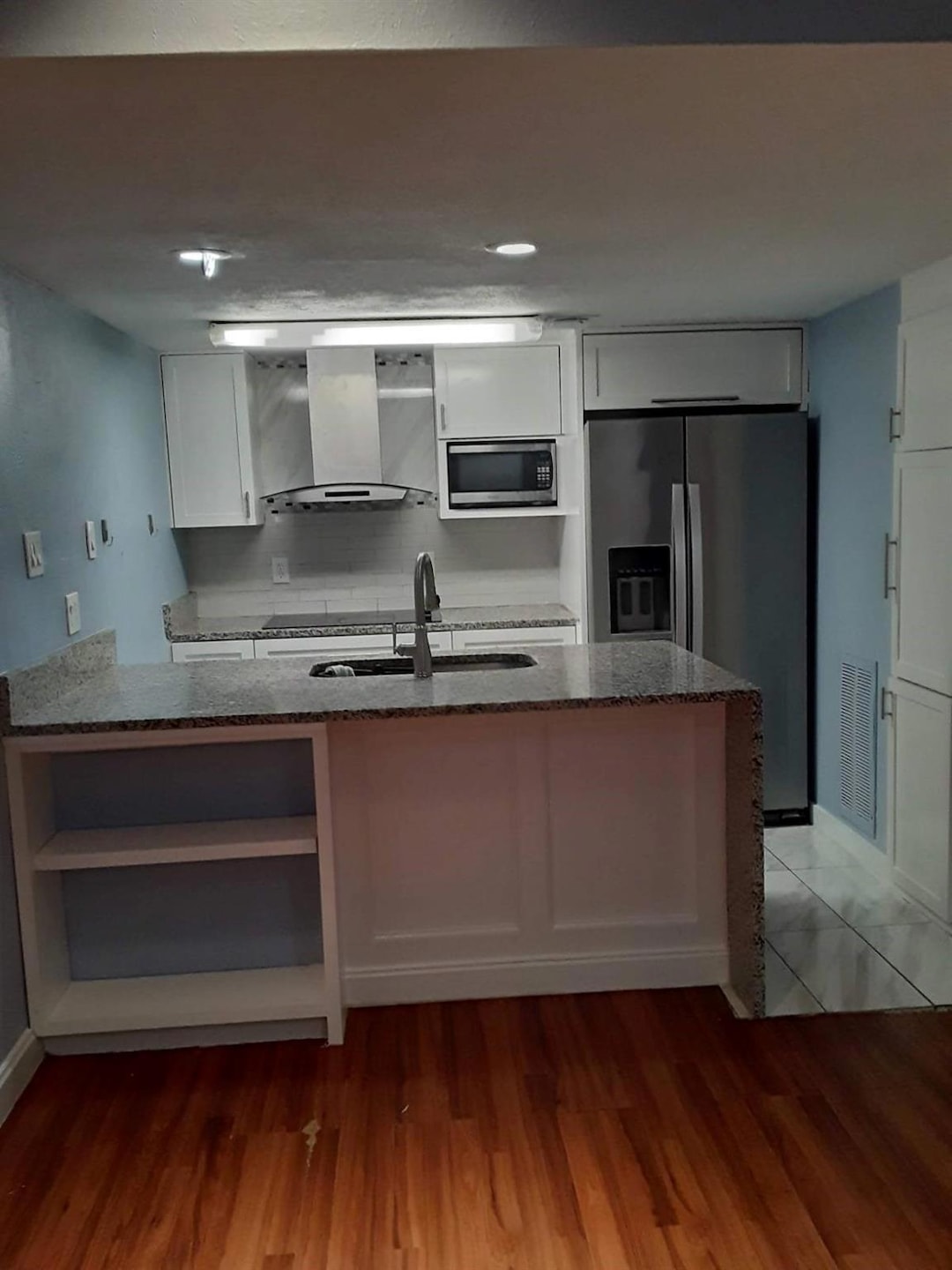 Kitchen featuring wall chimney range hood, stainle