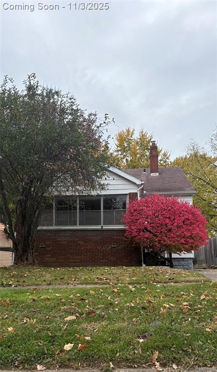 property with brick siding and a chimney