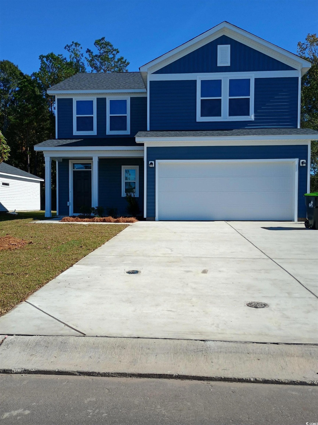 View of property with a garage and a front lawn