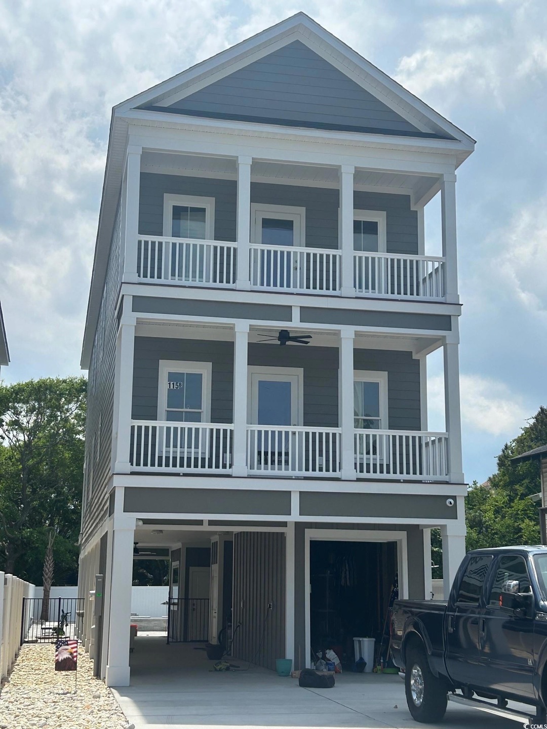 Coastal inspired home with fence, an attached gara