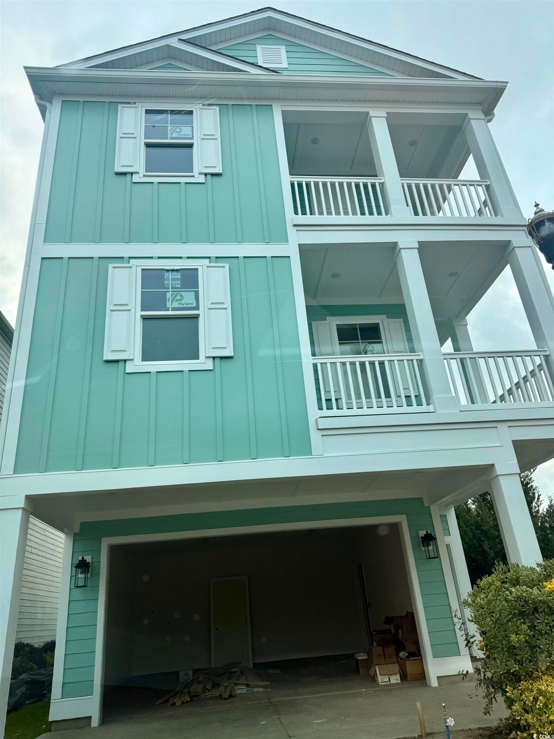 View of home's exterior with board and batten siding, a balcony, and an attached garage