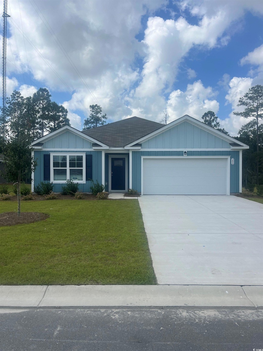 Ranch-style house featuring a front yard and a gar