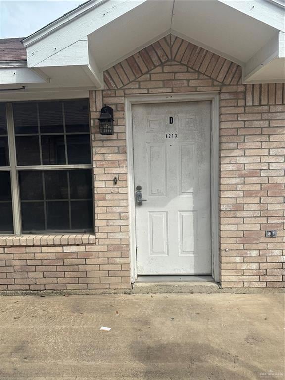 Doorway to property with brick siding