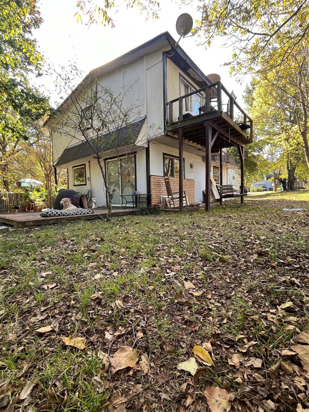 View of side of property featuring brick siding and a wooden deck