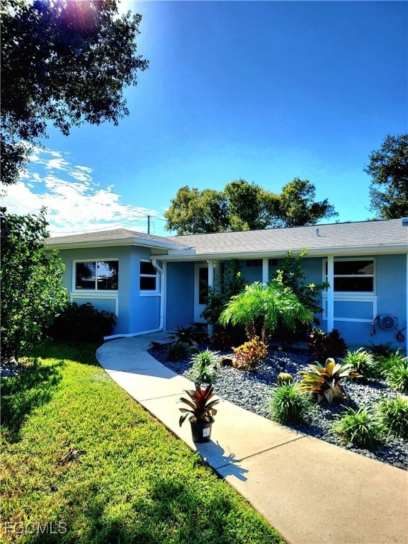 Single story home with a front lawn and stucco siding