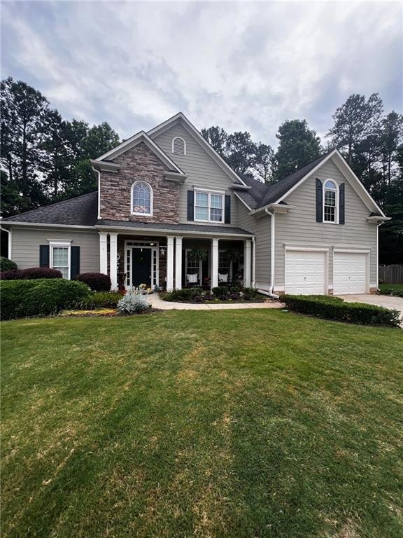 View of front of home with a garage and a front ya