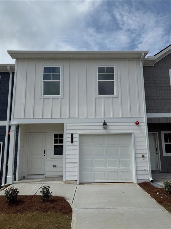 View of front of home featuring concrete driveway, an attached garage, and board and batten siding